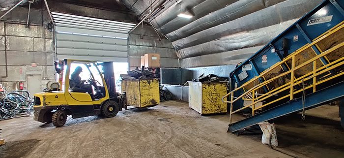 Forklift loading sorted scrap materials in a warehouse